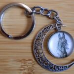 Porte clés Ane dessiné dans une bulle entouré d'une lune en métal